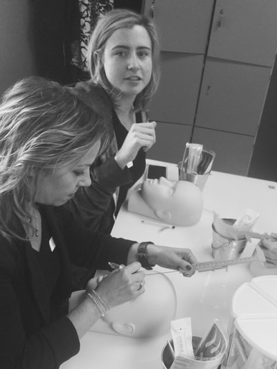 Student practicing eyebrow mapping on mannequin head at The Academy.