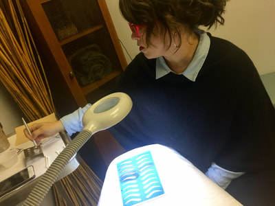 Student practicing hair strokes on practice skins at The Academy.